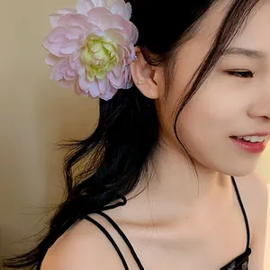 Dettaglio di un'elegante clip per capelli a forma di fiore in tessuto rosa su modella.