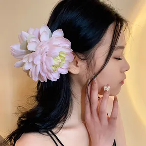 Vista dettagliata di un'elegante clip per capelli a fiore di stoffa rosa su un modello