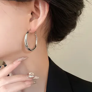 Close-up of a high-quality silver minimalist hoop earring worn by an Asian female model