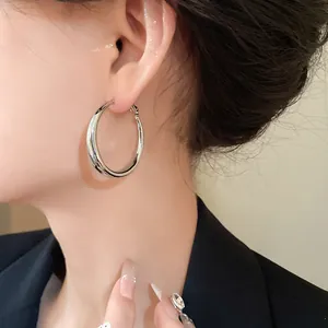 Close-up view of minimalist silver hoop earrings worn by a model for elegant style