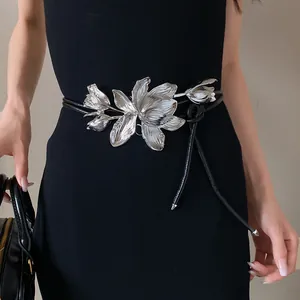 Close-up of vintage silver tulip metal flower on a thin black leather cord waist belt