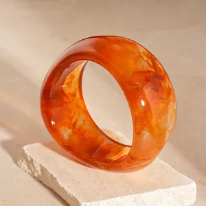 Elegant amber marbled acrylic wide bangle with an irregular wave design for women.