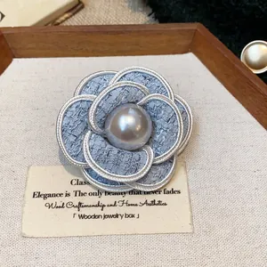 Elegant French style blue tweed camellia brooch featuring a central grey pearl detail