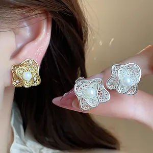 Close-up detail of elegant flower-shaped pearl clip-on earrings in gold and silver