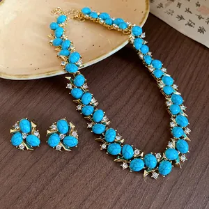 Dettaglio di un set di gioielli vintage con resina turchese e pietre di zircone.