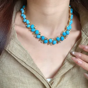 Primo piano dettagliato di una collana stile vintage con pietre in resina blu e zircone al collo