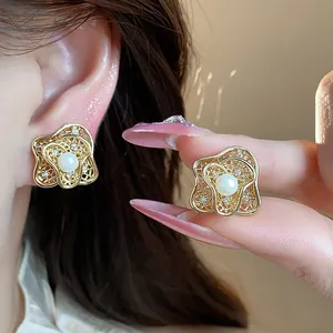 Detailed view of 18k gold plated flower pearl ear clips with crystal accents shown on ear.