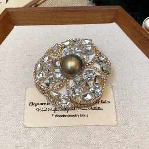 Detailed macro shot of French chic camellia flower brooch with rhinestones and central pearl