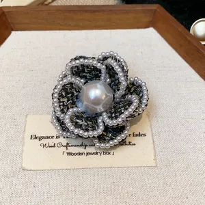 Detailed macro shot of a French style camellia brooch with tweed and pearl trim