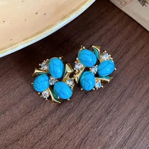 Primo piano dettagliato di orecchini vintage con resina turchese e zirconi scintillanti