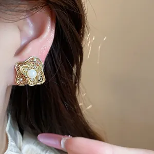 Detailed close-up view of elegant 18k gold plated flower clip-on earring with a central pearl