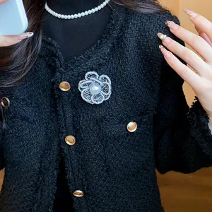 Exquisite white pearl camellia flower brooch pinned on a black tweed coat detail