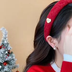 Close-up of elegant red flocked wide headband with a gold heart detail on model