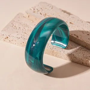 Niche teal marbled acrylic wide wave bangle with irregular surface on stone slabs
