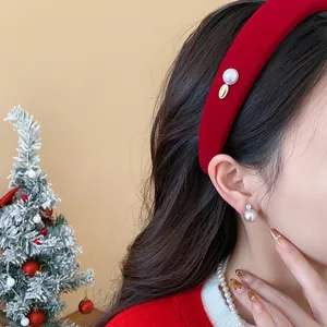 Elegant red flocked headband with pearl details worn by model in festive setting