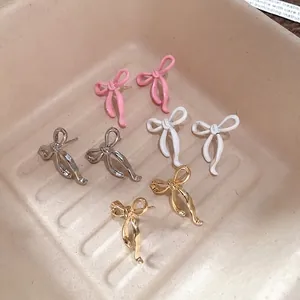 Eleganti orecchini a perno con fiocco in rosa, bianco, argento e finiture dorate