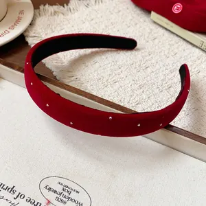 Detailed macro view of red velvet headband with pearl studs for autumn and winter fashion