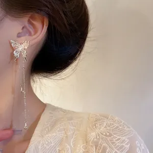 Elegant silver butterfly tassel earrings with delicate dangling chains worn by a model
