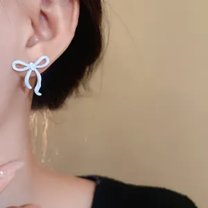 Eleganti orecchini a lobo a fiocco azzurro con perni in argento per un look dolce e sobrio.