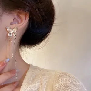 Close-up of textured butterfly tassel earring with delicate silver chain details