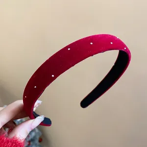 Macro detail of elegant red velvet wide headband featuring small white pearl dots