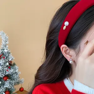 Detailed side view showing a white pearl and gold charm on a luxury red velvet headband