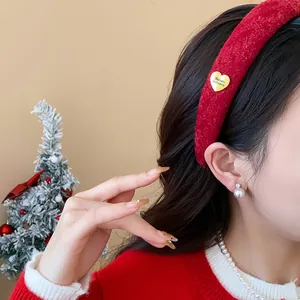 Detailed side view of a stylish red flocked headband featuring a gold heart charm