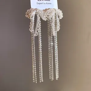 Elegant silver-toned bow earrings featuring sparkling cubic zirconia and long chain tassels