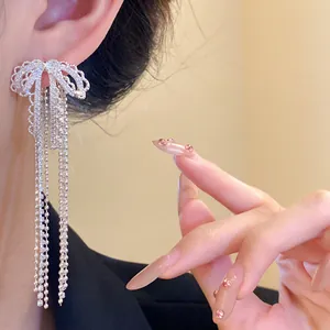 Detailed view of silver zircon bow tassel earrings with sparkling rhinestones