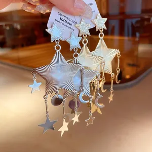 Gros plan détaillé de boucles d'oreilles en argent 925 avec étoiles et lune et fini texturé