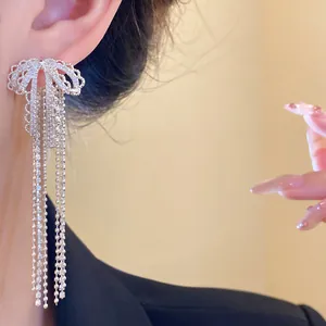 Detailed view of elegant silver bow tassel earrings with sparkling zirconia
