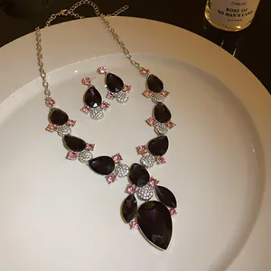 Detailed shot of vintage teardrop necklace set with purple stones and pink crystals