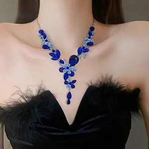 Close-up of elegant blue rhinestone floral necklace on model with black feather dress