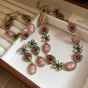 Macro view of vintage luxury jewelry set featuring red heart charms and floral designs