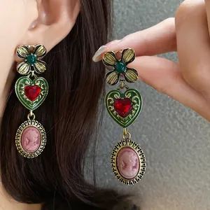 Vintage style dangle earrings featuring green flowers, red hearts, and pink cameo charms.