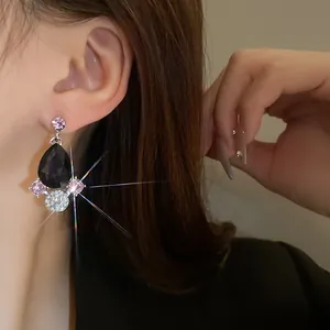 Close-up of vintage teardrop earrings with black gems and sparkling crystals