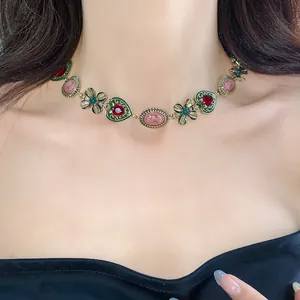 Close-up of vintage-style necklace with flower and heart charms worn on neck