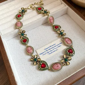 Vintage gold-tone necklace with red hearts, green flowers and pink cameos in a wooden jewelry box