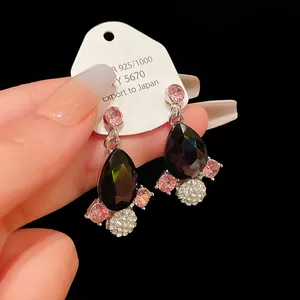 Detailed macro view of vintage royal style teardrop earrings with black and pink crystals.