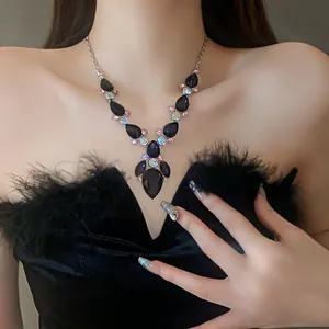 Detailed view of a vintage court style necklace with purple teardrop stones and rhinestones.