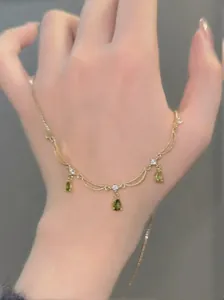 Vue détaillée d'un collier plaqué or 18k avec des pendentifs goutte en zircon vert.