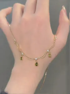 Vue détaillée d'un collier plaqué or 18 carats avec pendentifs gouttes en zircon vert.