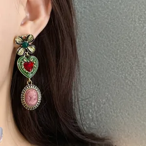 Macro view of vintage-style floral heart earring with pink cameo pendant detail