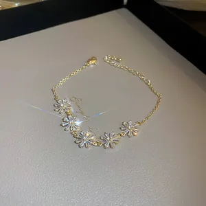 Elegant gold-plated flower bracelet featuring sparkling cubic zircon stones for women.