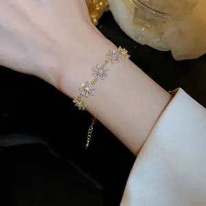 Detailed view of elegant gold-plated flower bracelet with sparkling cubic zirconia on wrist