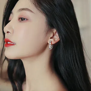 Side view of elegant C-shaped hoop earrings with cat-eye stones and rhinestones