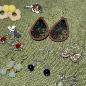Close-up of assorted bohemian and modern style earrings displayed on a green texture