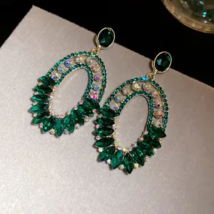 Macro detailed shot of vintage style oval emerald green crystal and AB rhinestone earrings