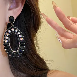 Detail of vintage oval drop earrings with black stones and iridescent crystals