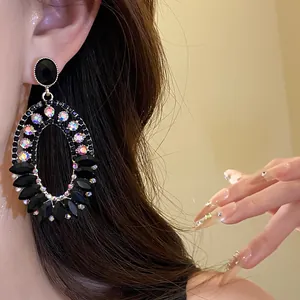 Close-up detail of vintage oval dangle earrings with black and iridescent stones